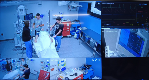 Video monitor of students being observed in simulation.